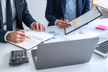 İş dünyası ekibi liderleri, meslektaşlarına sunum ve iş stratejisi üzerinde çalışıyor ve bir tartışma yapıyorlar, grafik ve grafiğe işaret ederek, işbirliği ortaklığının başarısına işaret ediyorlar..