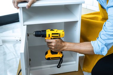 Evinde tadilat yapan bir adam dolaptaki matkapla odun deliyor..