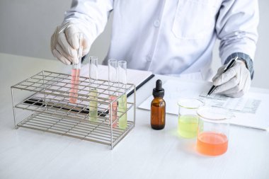 Biyokimya laboratuvarı araştırması. Kimyager laboratuvarda kimyasal sıvı içeren ekipman ve bilimsel deneylerle numune analiz ediyor..