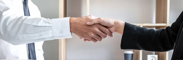 Greeting new colleagues, Handshake while job interviewing, male candidate shaking hands with Interviewer or employer after a job interview, employment and recruitment concept.