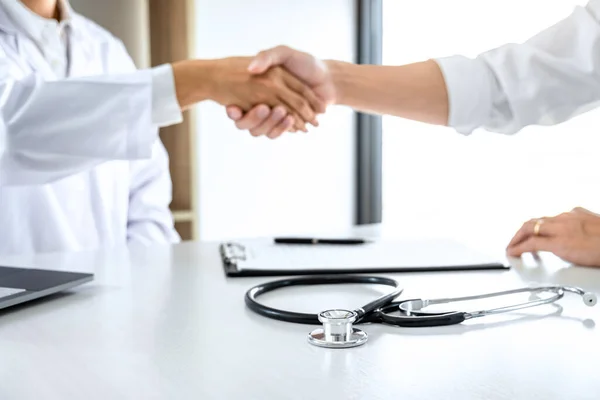 Medicine and health care concept, Professional Male doctor in white coat handshake with patient after successful recommend treatment methods.