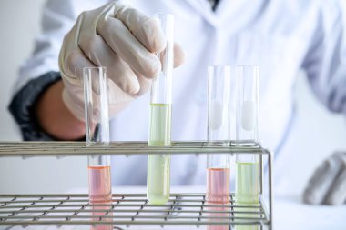 Biyokimya laboratuvarı araştırması. Kimyager laboratuvarda kimyasal sıvı içeren ekipman ve bilimsel deneylerle numune analiz ediyor..