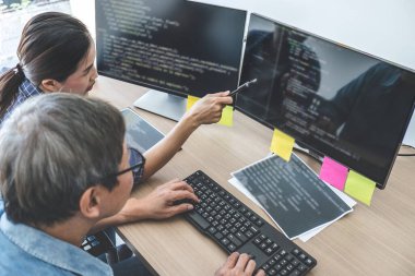 Kodlar yazma ve veri kodu teknolojisi yazma, iki profesyonel programcı şirketteki masaüstü bilgisayarında geliştirilen bir yazılımda web sitesi projesinde işbirliği yapıyor..