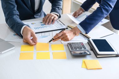 İş dünyası ekibi liderleri, meslektaşlarına sunum ve iş stratejisi üzerinde çalışıyor ve bir tartışma yapıyorlar, grafik ve grafiğe işaret ederek, işbirliği ortaklığının başarısına işaret ediyorlar..