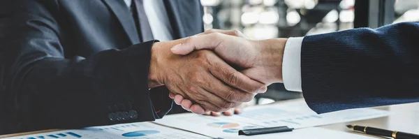 Teamwork partnership meeting concept, Two confident Business shaking hands after discussing good deal of trading contract and new projects for both companies.