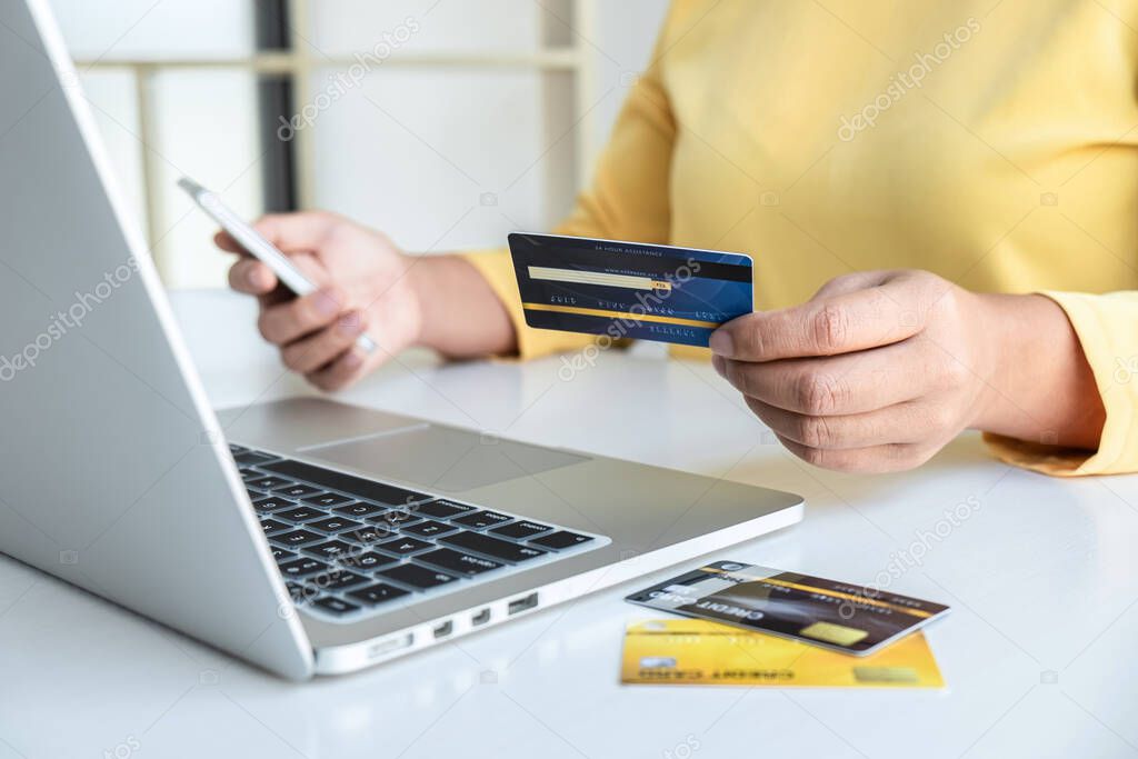 Woman using credit card and smartphone register security code payments online shopping and customer service network connection market, using technology on laptop, Internet Online shopping concept.