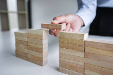 İş dünyasında plan ve strateji, İş Büyütme Riski Ahşap bloklar ile İş Büyüme Konsepti, insan eli yığılır ve ahşap bir blok istifleme.