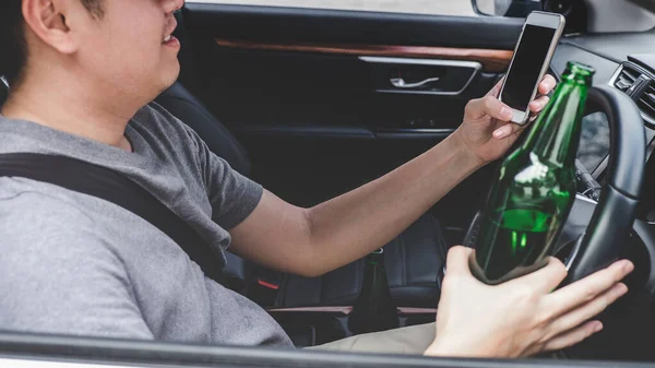 Νεαρός Ασιάτης Οδηγεί Ένα Αυτοκίνητο Ένα Μπουκάλι Μπύρα Και Χρησιμοποιεί — Φωτογραφία Αρχείου