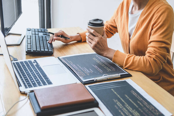 Молодой программист, работающий в офисе компании над программированием и веб-сайтом, пишет коды и кодирует код данных, программирует с помощью HTML, PHP и javascript.