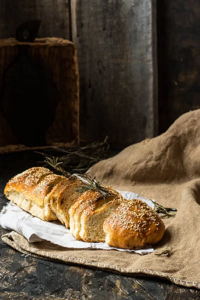 Freshly baked wheat bread on natural linen napkin and bag. Homemade bakery. Still life of bread. Slice of gold rustic crusty loave of bread. — Stock Photo, Image