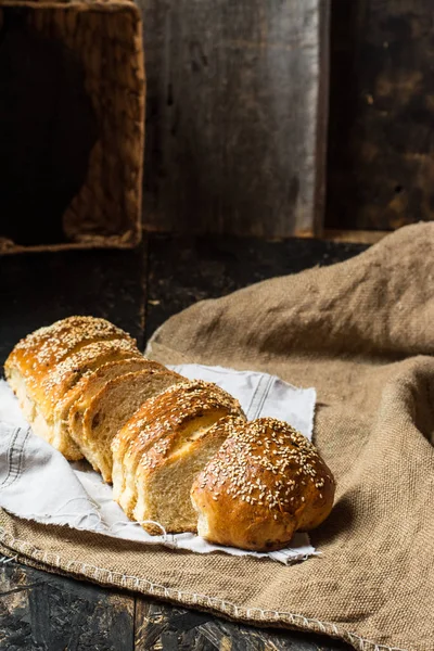 Freshly baked wheat bread on natural linen napkin and bag. Homemade bakery. Still life of bread. Slice of gold rustic crusty loave of bread. — Stock Photo, Image