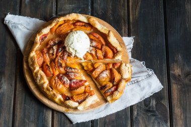  Ev yapımı kayısı Galette'ye ahşap masa, üstten görünüm üzerinde taze organik apricotes ile yaptı. Pişirme işlemi. Açık pasta, kayısı tart. Meyve ekmek. Sıcak pasta ile soğuk dondurma.