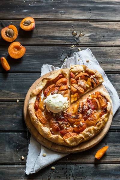 Ev yapımı kayısı Galette'ye ahşap masa, üstten görünüm üzerinde taze organik apricotes ile yaptı. Pişirme işlemi. Açık pasta, kayısı tart. Meyve ekmek. Sıcak pasta ile soğuk dondurma.