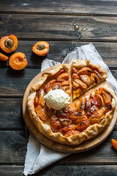 Ev yapımı kayısı Galette'ye ahşap masa, üstten görünüm üzerinde taze organik apricotes ile yaptı. Pişirme işlemi. Açık pasta, kayısı tart. Meyve ekmek. Sıcak pasta ile soğuk dondurma.