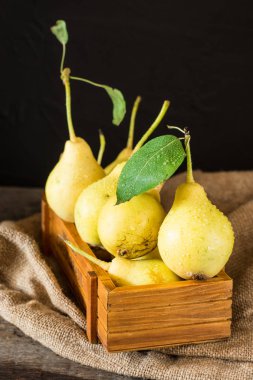 Olgun armut masada mezarda. Taze olgun organik armut rustik ahşap tablo, doğal arka plan, vega, Diyet yemekleri. Sonbaharda hasat. Çanta üzerinde sulu meyveler.