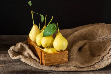 Olgun armut masada mezarda. Taze olgun organik armut rustik ahşap tablo, doğal arka plan, vega, Diyet yemekleri. Sonbaharda hasat. Çanta üzerinde sulu meyveler.