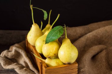 Olgun armut masada mezarda. Taze olgun organik armut rustik ahşap tablo, doğal arka plan, vega, Diyet yemekleri. Sonbaharda hasat. Çanta üzerinde sulu meyveler.