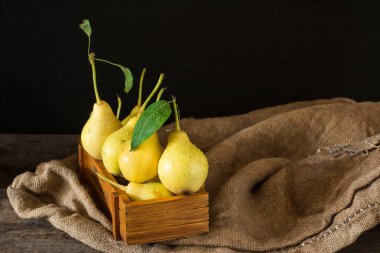 Olgun armut masada mezarda. Taze olgun organik armut rustik ahşap tablo, doğal arka plan, vega, Diyet yemekleri. Sonbaharda hasat. Çanta üzerinde sulu meyveler.