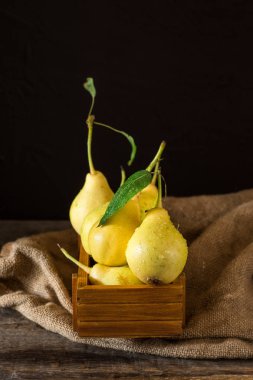 Olgun armut masada mezarda. Taze olgun organik armut rustik ahşap tablo, doğal arka plan, vega, Diyet yemekleri. Sonbaharda hasat. Çanta üzerinde sulu meyveler.