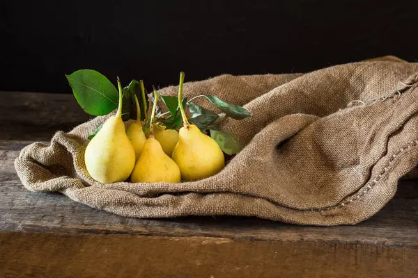 Taze olgun organik armut rustik ahşap tablo, doğal arka plan, vega, Diyet yemekleri. Sonbaharda hasat. Çanta üzerinde sulu meyveler.