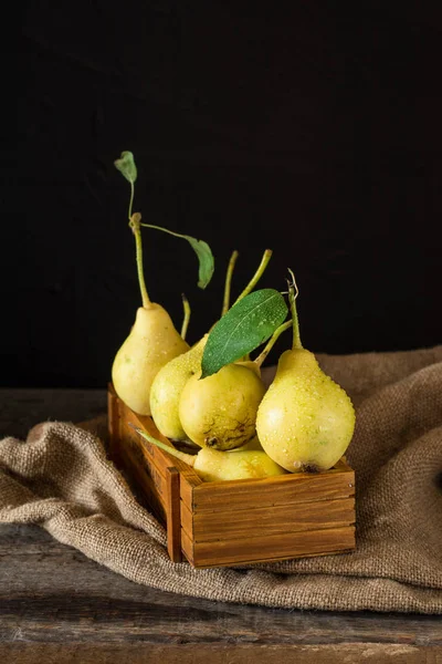 Olgun armut masada mezarda. Taze olgun organik armut rustik ahşap tablo, doğal arka plan, vega, Diyet yemekleri. Sonbaharda hasat. Çanta üzerinde sulu meyveler.