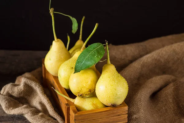 Olgun armut masada mezarda. Taze olgun organik armut rustik ahşap tablo, doğal arka plan, vega, Diyet yemekleri. Sonbaharda hasat. Çanta üzerinde sulu meyveler.