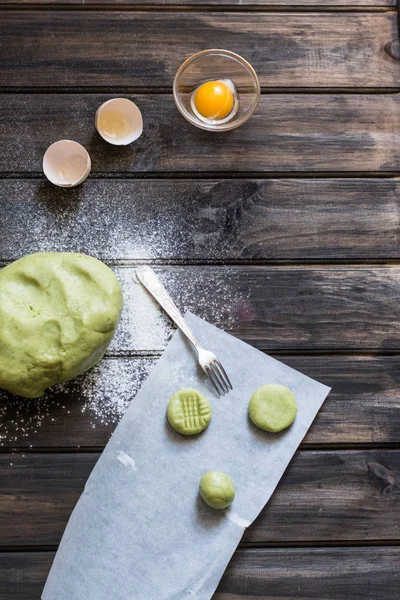 Raw mint and orange chip cookies on wooden table. Color dough. Mint cookies. Orange cookies. Process of baking. Homemade bakery. Raw cookies.