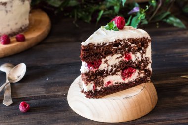 Bölümü ile katmanlı Kremalı meyveli kek içinde görünümü kapatın. Çikolata ahududu cake. Çikolatalı kek. Nane dekorasyon. Ahşap masa üzerinde peynirli kek. Gıda natürmort. Kara Orman pastası