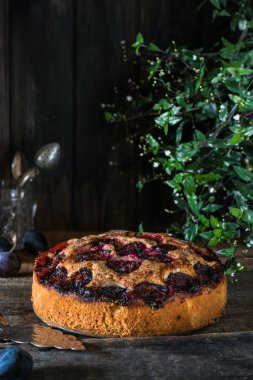 Eski ahşap zemin üzerine ev yapımı erik turtası. Vintage kaşık. Gıda natürmort. Erik tart. Sonbaharda hasat. Eski moda mutfak. Pasta kısmı. Erik fırını. Rustik açık pasta.