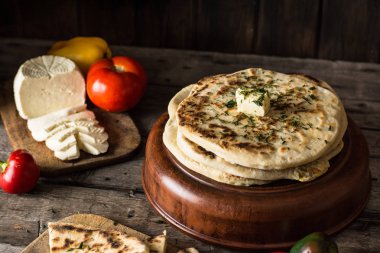 Beyaz peynir ve domates ve biber ile ahşap tahta üzerinde pide. Gıda natürmort. Gürcü mutfağı. İspanyol yemeği. Ulusal mutfağı. geleneksel çanak ahşap masa üzerinde. Akdeniz mutfağı.