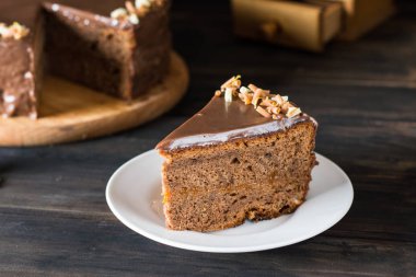 Ahşap üzerinde beyaz bir tabakta çikolatalı kek parçası. Geleneksel Avusturya kek. Sacher kek. Kayısı pasta. Kahvaltı kavramı. Kahve zamanı. Gıda natürmort. Çikolata dekorasyon. Noel kek.
