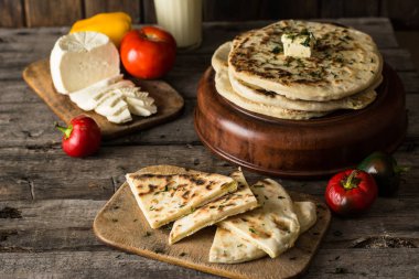 Beyaz peynir ve domates ve biber ile ahşap tahta üzerinde pide. Gıda natürmort. Gürcü mutfağı. İspanyol yemeği. Ulusal mutfağı. geleneksel çanak ahşap masa üzerinde. Akdeniz mutfağı.