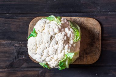 Karnabahar bıçak ile ahşap tahta üzerinde. Gıda natürmort. Pişirme işlemi. Vejetaryen kavramı. Pişirme kavramı. Vegan gıda. Lahana. Organik gıda.