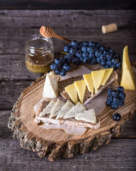 Verschiedene Käsesorten Mit Trauben Brot Honig Auf Dunklem Holz Hintergrund — Stockfoto