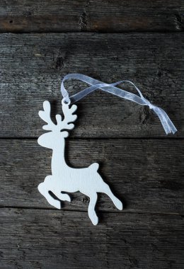 Noel ahşap dekorasyon şeklinde bir geyik. Dekorasyon ahşap bir duvar. Beyaz oyuncak bir boynuzlu geyik şeklinde. Çevre dostu oyuncak. Noel dekorasyonu. Melek