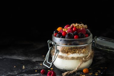 Yoğurt pişmiş granola ve çilek kavanoza. Ahududu, yaban mersini, vegan gıda. fındık ve bal. Sağlıklı gıda. Vejetaryen granola. Sağlıklı snack.