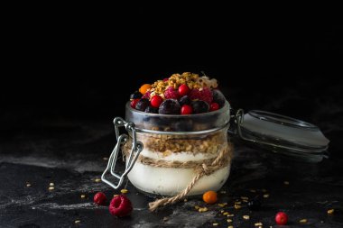Yoğurt pişmiş granola ve çilek kavanoza. Ahududu, yaban mersini, vegan gıda. fındık ve bal. Sağlıklı gıda. Vejetaryen granola. Sağlıklı snack.