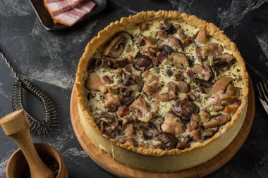 Mantarlı kiş pasta petrol ve koyu arka plan, üstten görünüm üzerinde peynir ile. Mantar ile tuzlu tart. Galette'ye. Tavuk ile tart. Tavuklu böreği. Mantar pasta