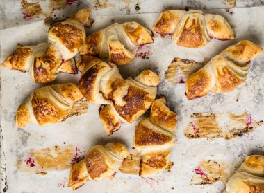 Parşömen kağıtları, üstten görünüm üzerinde taze pişmiş kruvasanlar. Kahvaltı. Kahve zamanı. Kahve molası. Brunch. Fransız öğle yemeği. Fransız Kahvaltı