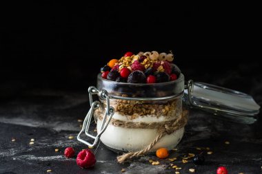 Yoğurt granola ve meyveleri küçük kavanoz, çilek, yaban mersini., Siyah frenk üzümü. tatlılık. Ev yapımı yoğurt. Sağlıklı gıda. Sağlıklı yemek. Vejetaryen. Vejetaryen. Sağlıklı kahvaltı. Bal granola