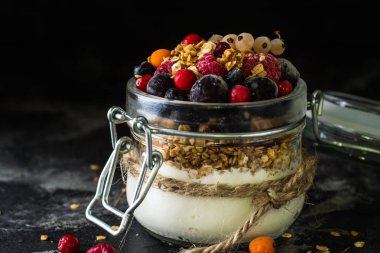 Yoğurt granola ve meyveleri küçük kavanoz, çilek, yaban mersini., Siyah frenk üzümü. tatlılık. Ev yapımı yoğurt. Sağlıklı gıda. Sağlıklı yemek. Vejetaryen. Vejetaryen. Sağlıklı kahvaltı. Bal granola