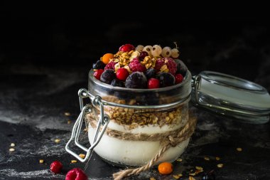 Yoğurt granola ve meyveleri küçük kavanoz, çilek, yaban mersini., Siyah frenk üzümü. tatlılık. Ev yapımı yoğurt. Sağlıklı gıda. Sağlıklı yemek. Vejetaryen. Vejetaryen. Sağlıklı kahvaltı. Bal granola