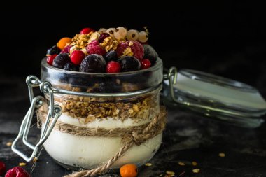 Yoğurt granola ve meyveleri küçük kavanoz, çilek, yaban mersini., Siyah frenk üzümü. tatlılık. Ev yapımı yoğurt. Sağlıklı gıda. Sağlıklı yemek. Vejetaryen. Vejetaryen. Sağlıklı kahvaltı. Bal granola