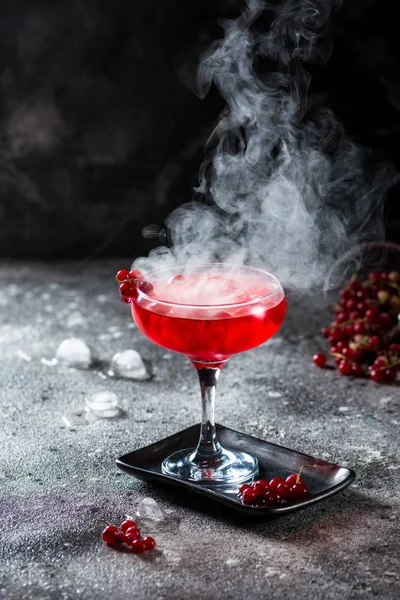 Cocktail rouge avec vapeur de glace. Cocktail avec fumée. Boisson alcoolisée, vodka, glace, fête, glace sèche . — Photo