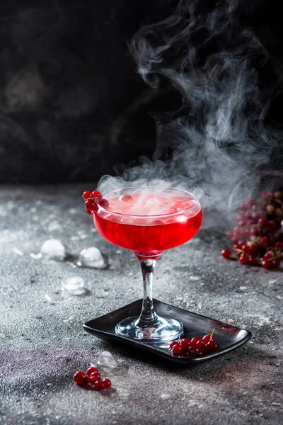 Cocktail rouge avec vapeur de glace. Cocktail avec fumée. Boisson alcoolisée, vodka, glace, fête, glace sèche . — Photo