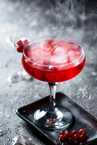 Cocktail rouge avec vapeur de glace. Cocktail avec fumée. Boisson alcoolisée, vodka, glace, fête, glace sèche . — Photo