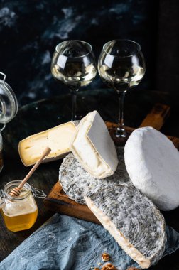 Çeşitli peynir kompozisyonu. Gorgonzola, camembert peyniri. Rokfor, mavi alarm. Ceviz ve şarap. Aperatif ve gurme yemekleri. Kavanozda bal