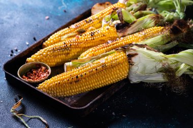 Tuzlu, kırmızı biberli ve tereyağlı ızgara mısır. Organik yiyecekler, vejetaryen yemekler. Barbekü, bbq. Mısır, mısır, tahıl. Organik gıda, sağlıklı beslenme.