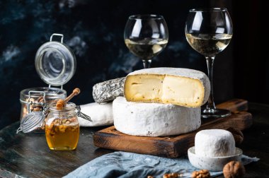 Çeşitli peynir kompozisyonu. Gorgonzola, camembert peyniri. Rokfor, mavi alarm. Ceviz ve şarap. Aperatif ve gurme yemekleri. Kavanozda bal