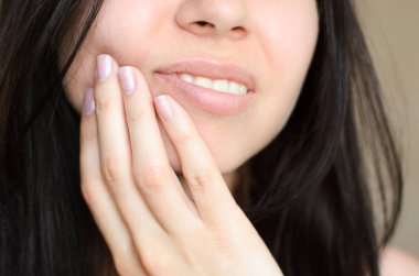 Bir kız onun yüzüne diş ağrısı nedeniyle dokunur veya başka bir ağrı yakın çekim